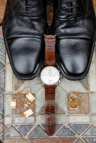 Obraz Stylish men's accessories close-up. Leather black men's shoes, watch, gold rings and chains with a cross for a male. Photo of groom's accessories top view. Details of men's outfit