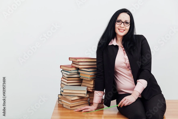 Fototapeta Woman teacher in suit and table with stacks of library books