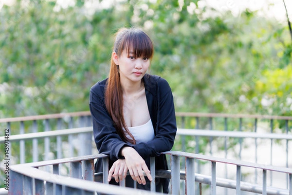 Obraz Portrait of beautiful asian Young woman in Black robe sportswear working out outside. training on public equipment in outdoor at park. concept Exercise Healthy lifestyle.