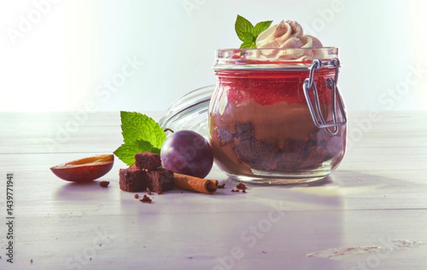 Fototapeta Schokopudding mit Pflaumen und Sahnetupfer in Einmachglas, Obst, Kompott, Pflaumenkompott, Dessert
