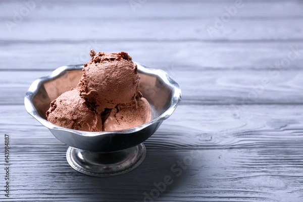 Fototapeta Tasty ice-cream in bowl on wooden table