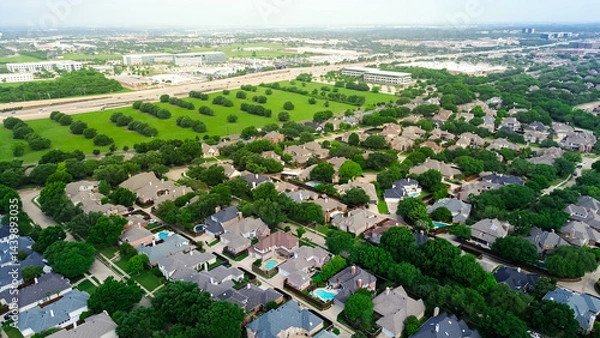 Fototapeta Vacant land with trees along Dallas North Tollway in rapid growing mixed use development area of business park campus buildings, upscale residential neighborhood home along West Plano Parkway
