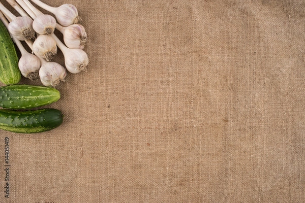 Fototapeta cucumbers and garlic on a sacking.