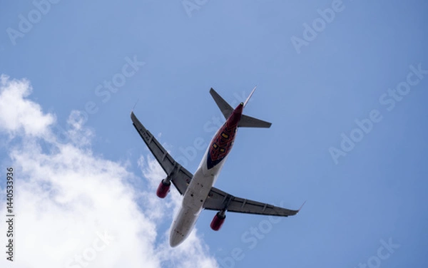 Fototapeta Bottom view of a commercial airplane taking off into the cloudy sky from Soekarno-Hatta International Airport, Jakarta.
