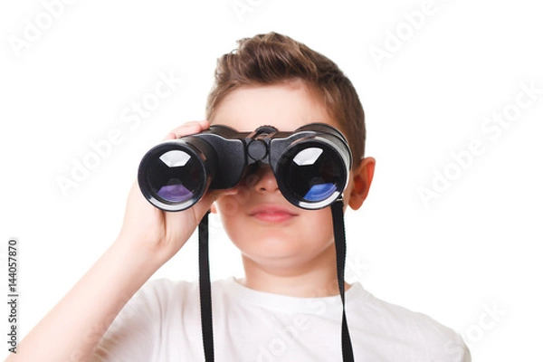 Fototapeta little boy is looking through binoculars. Isolated over white