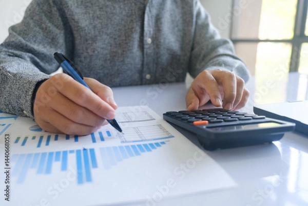 Obraz Close up accountant banker or bookkeeper making calculations with calculator.