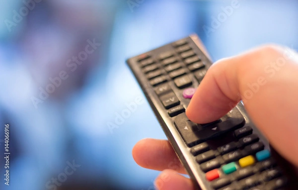 Obraz Fernbedienung vor Fernseher in Männerhand