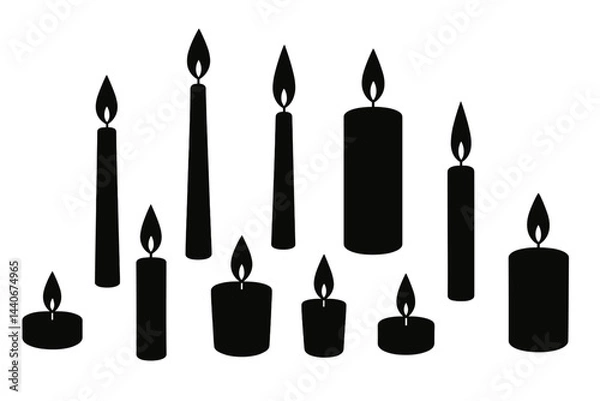 Fototapeta Collection of black candles with flames arranged in various heights on a white background
