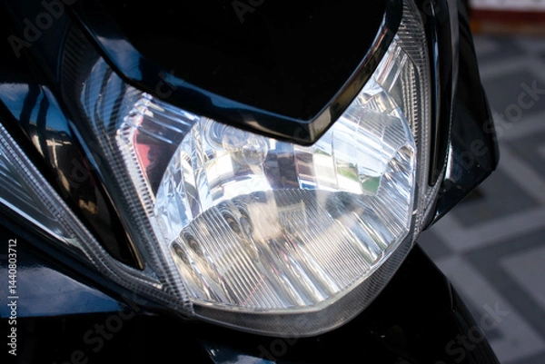 Fototapeta Close up of the main headlight design on an automatic scooter, showcasing the modern and angular shape of the lamp housing