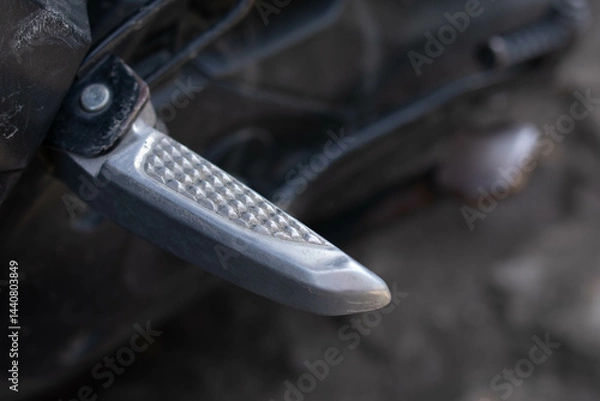 Fototapeta Close up of a motorcycle footrest or footpeg, showing a metal surface with grip texture used for rider foot support and stability