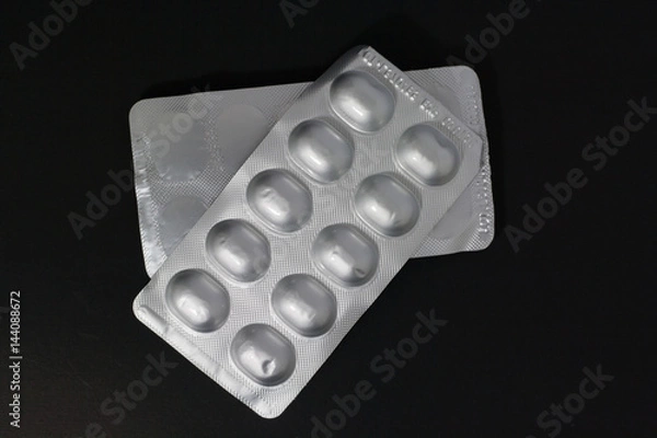 Obraz Closeup. Medication tablets packaged in a panel on a black background.