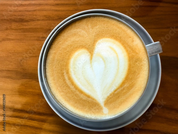 Fototapeta Overhead view of creamy coffee with love heart shape on top