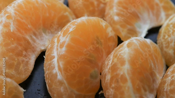 Obraz From a close up of the photo of neatly lined orange oranges with black tools, the photo shot is seen from the side