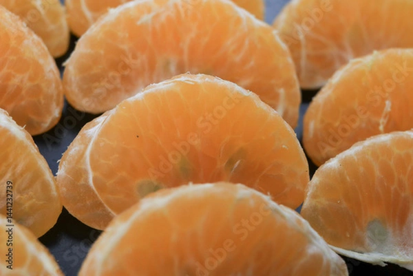 Obraz From a close-up photo, neatly arranged orange oranges with black tools.