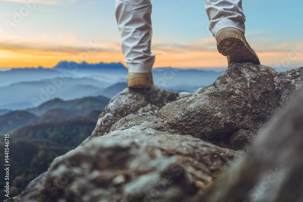 Obraz Hiker legs with boots standing on top mountain sunset background. Hiker men's hiking living healthy active lifestyle..