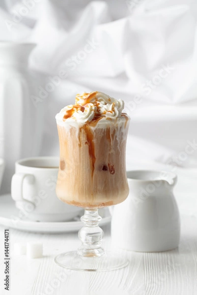 Fototapeta Iced caramel latte topped with whipped cream and caramel sauce.