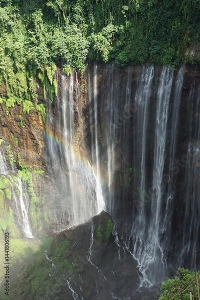 Fototapeta Majestic waterfall cascading down lush green cliffs indonesia nature photography scenic view serenity and beauty