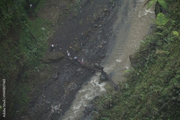 Obraz Crossing a river locals navigate the jungle terrain aerial view nature scene remote environment