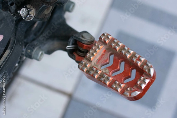 Fototapeta Close up of a motorcycle footrest or footpeg, showing a metal surface with grip texture used for rider foot support and stability