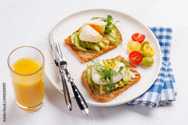 Fototapeta Delicious avocado toasts topped with perfectly cooked poached eggs