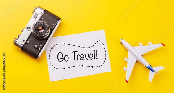 Fototapeta Travel-themed flat lay with blank photo card, camera and toy airplane,
