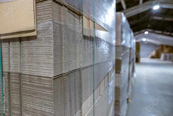 Obraz Folding cardboard boxes. Perforated sheets of corrugated cardboard a stack on pallets. Packaging of finished products in industrial production.