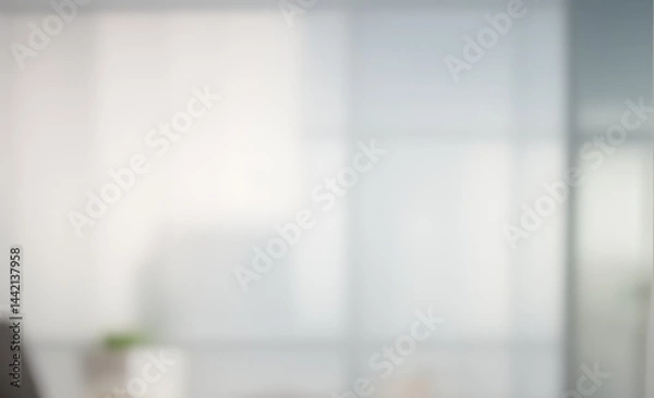 Fototapeta Blurred office interior with light colors and a hint of green plant.