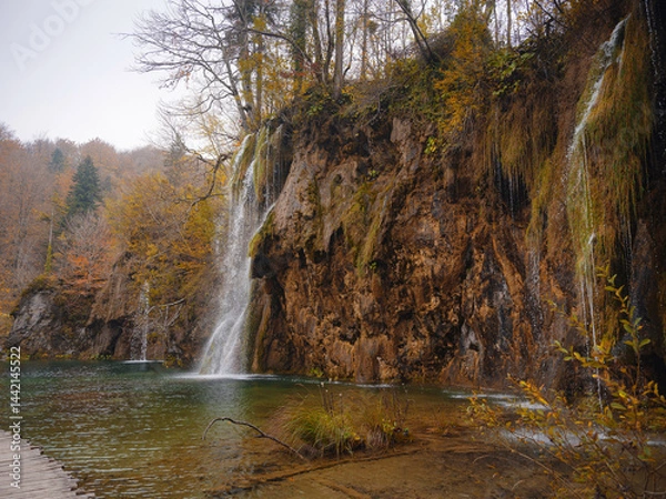 Fototapeta Plitvice Lakes in Croatia during autumn, showcasing stunning waterfalls, vibrant foliage, and crystal-clear waters, creating a magical and serene natural landscape perfect for nature lovers.