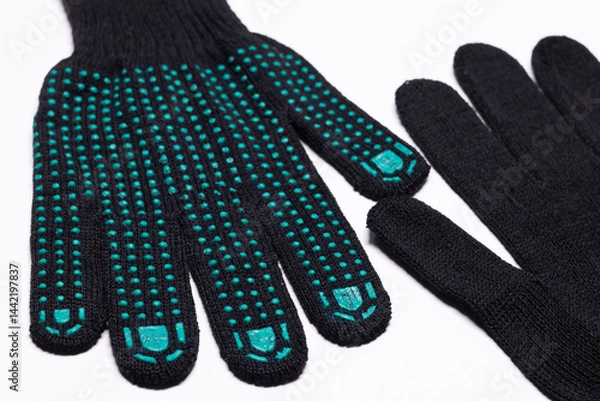 Fototapeta Pair of black work gloves with green rubber grip dots, front and back view on white background