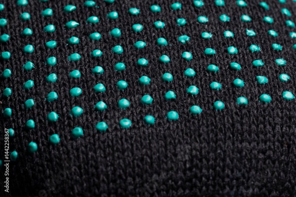 Fototapeta Close-up of black fabric with green rubber dots texture