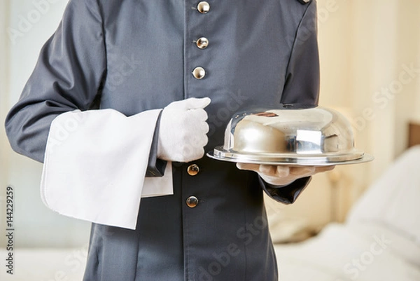 Obraz Urzędnik hotelowy serwujący jedzenie z kloszem