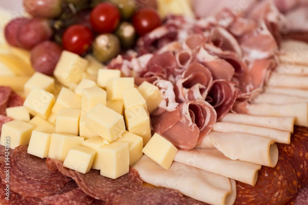 Obraz Tray with bacon, cheese cubes, salami, ham; decorated with grapes