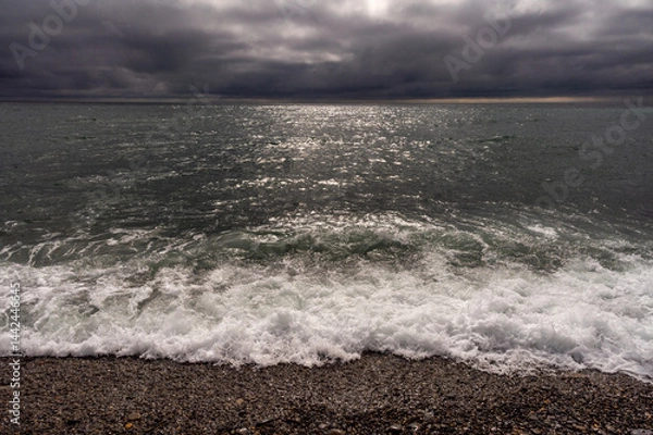 Fototapeta Dark storm clouds over ocean. Dramatic seascape. Clouds and rain flurry over sea.