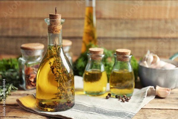 Fototapeta Olive oil with spices on wooden background