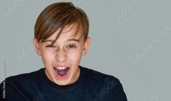 Fototapeta Young man screaming, isolated gray background. Scream. Child with angry expression. Shocked panic kid boy, screaming in despair, frustration.Young angry boy yelling