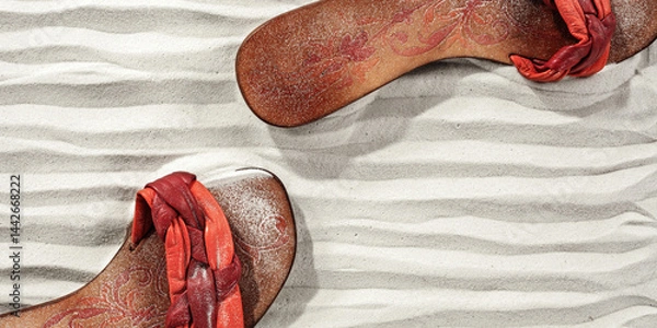 Fototapeta Leather flip-flops on sandy beach on hot summer day. Abstract small sand dunes beach background and place for product placement, text, logo, digital elements, creative projects or editorials.
