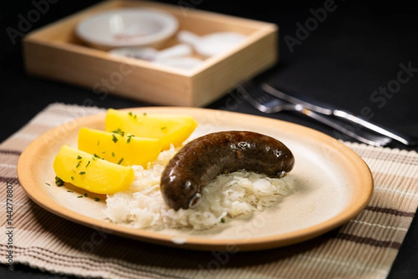 Obraz Bavarian blood sausage with sauerkraut and potatoes lying on a plate