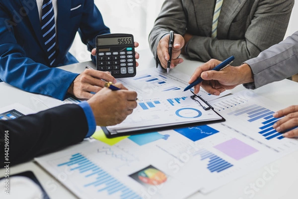 Obraz Financial advisor meeting and working with data using calculator and pointing at chart. Business professional collaborate, analyze financial data, and planning in a meeting.