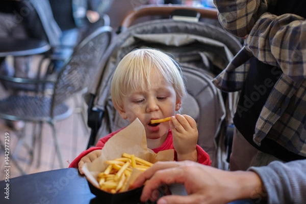 Fototapeta Father having lunch with sons in the shopping centre