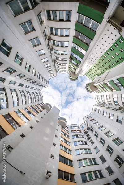 Obraz view from bottom up to the sky in a skyscraper house well with a narrow yard