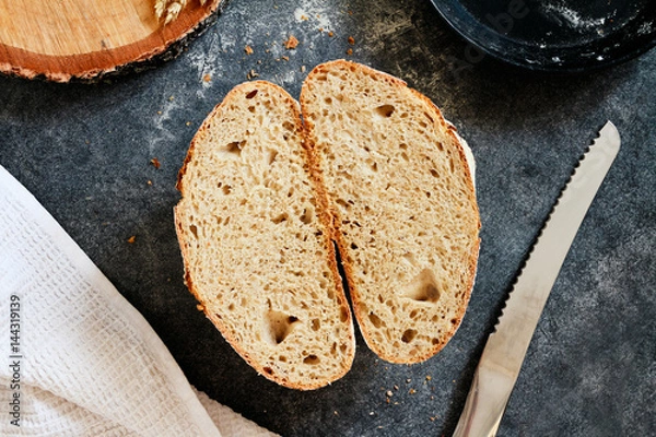 Fototapeta Section of homemade loaf of bread on a gray background. Selective focus
