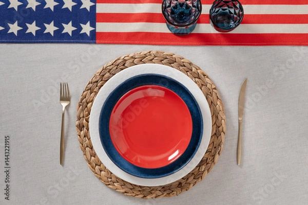 Obraz Patriotic table setting for USA Independence Day. Festive dinner with empty red plate and decoration in USA national flag colors white, red and blue. View from above. Copy space.