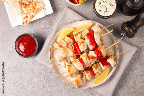 Fototapeta Grilled chicken skewers. Satay with side lemon and salad. Kebab with sauces. 