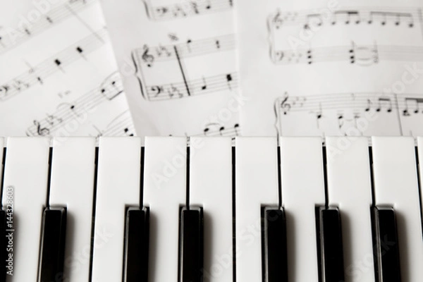 Obraz piano keyboard on blured music-notes background