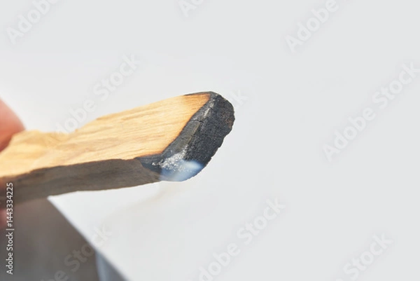 Fototapeta Close up of burning palo santo wood stick with smoke for aromatherapy and purification.