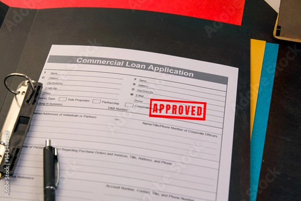 Fototapeta Commercial loan application with approved stamp on desk