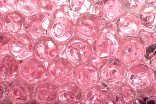 Fototapeta A macro close-up reveals a dense cluster of translucent pink gel beads, showing their round shapes and internal reflections