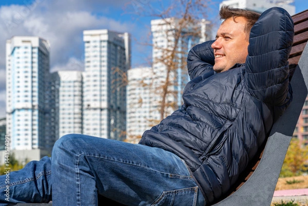 Obraz Urban Relaxation: A Man Enjoys Downtime on Bench with Cityscape