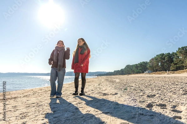 Obraz Two women walking on the seashore. Two friends enjoying and spending time together.