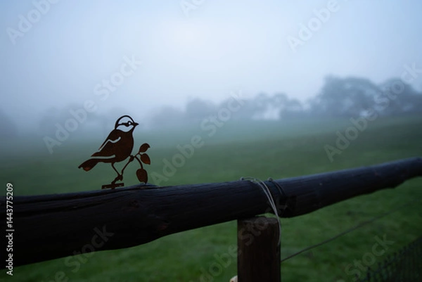 Obraz metal art in the shape of a bird on a fence